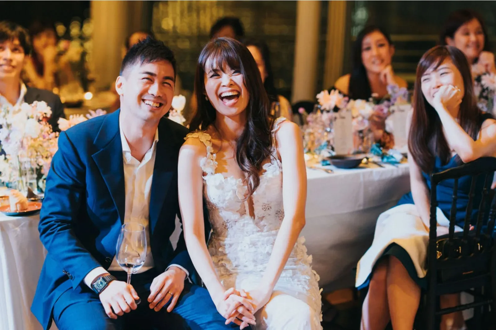 Wedding guests laughing at their table during a segment hosted by James Yang